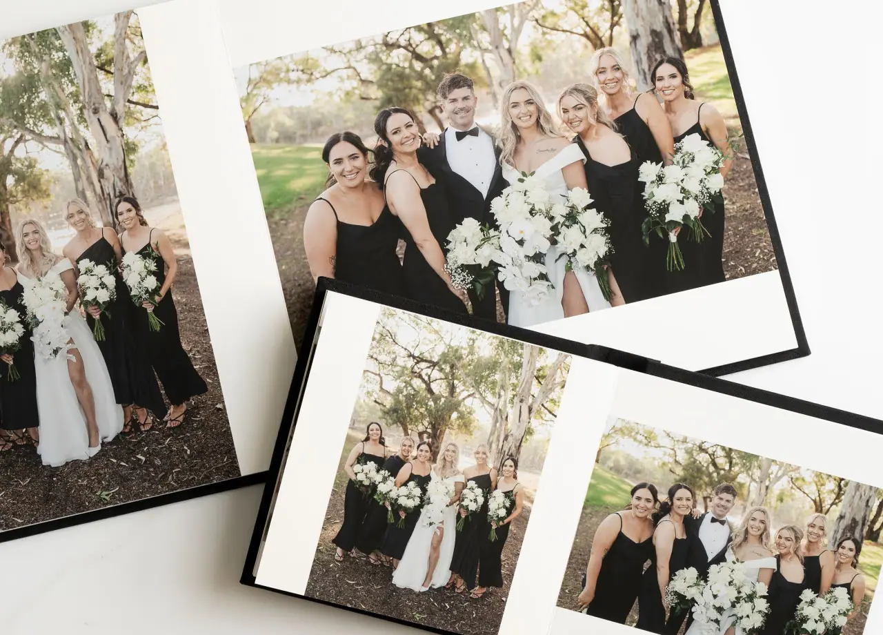 Open wedding albums showing group portraits and ceremony photographs.