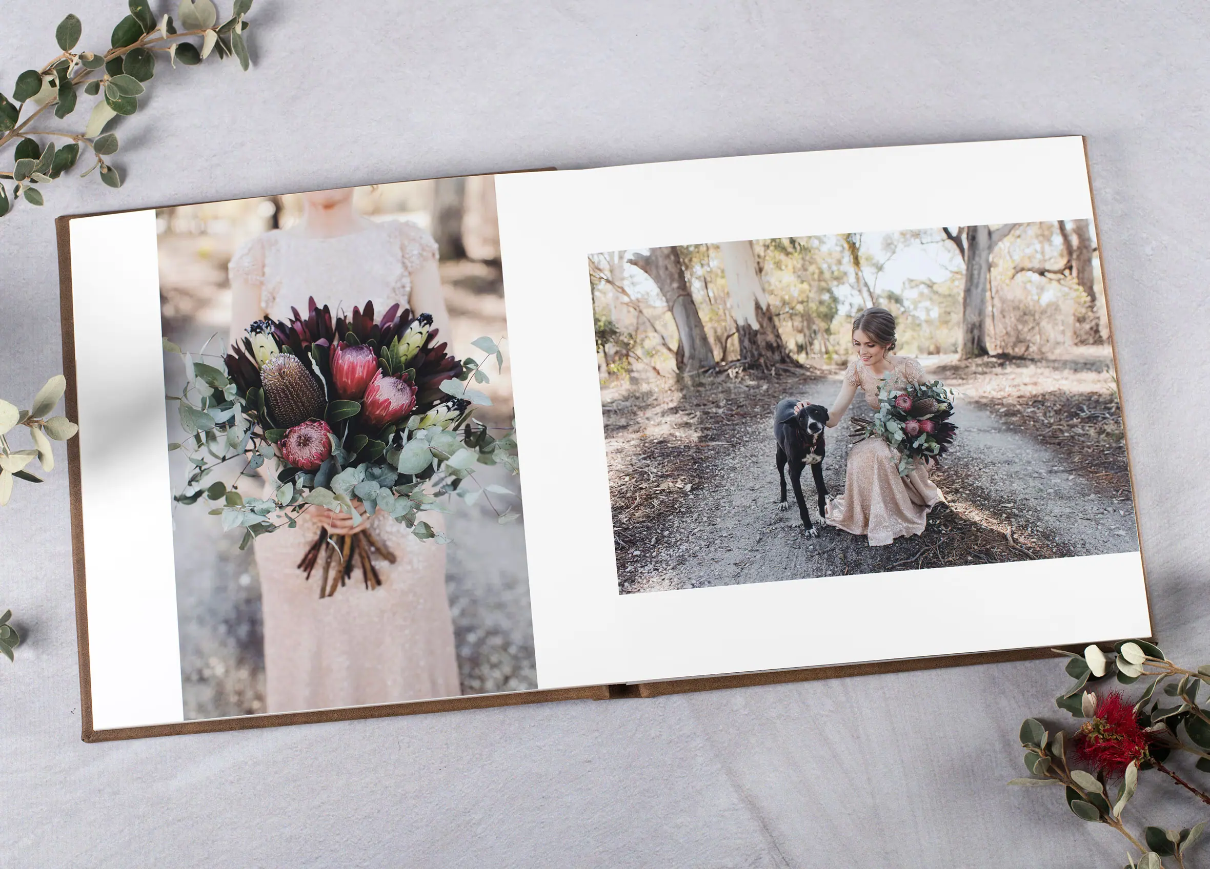 Open wedding album displaying a bouquet and a couple in woodland.