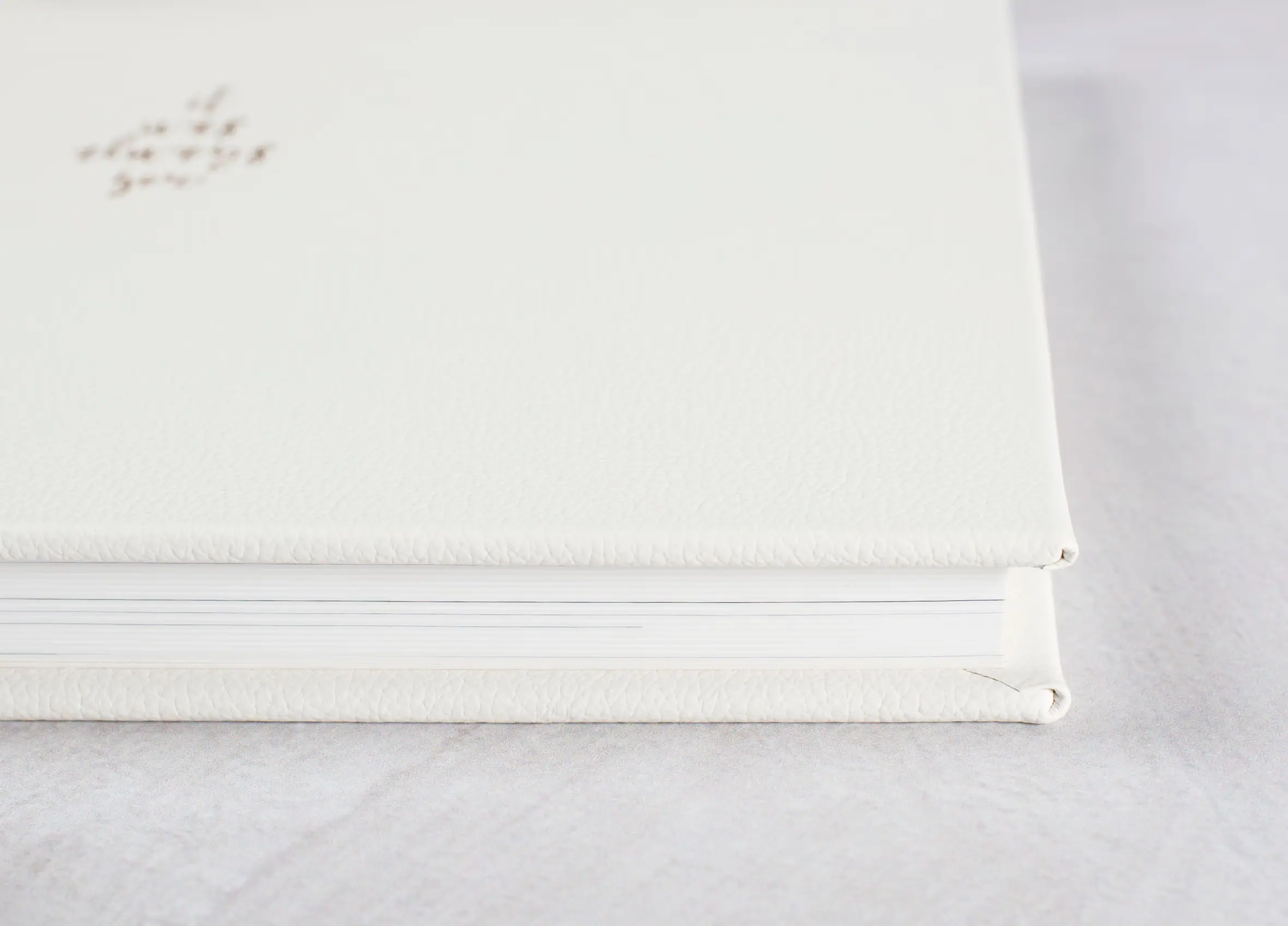Close-up of a white wedding album cover and its thick pages.