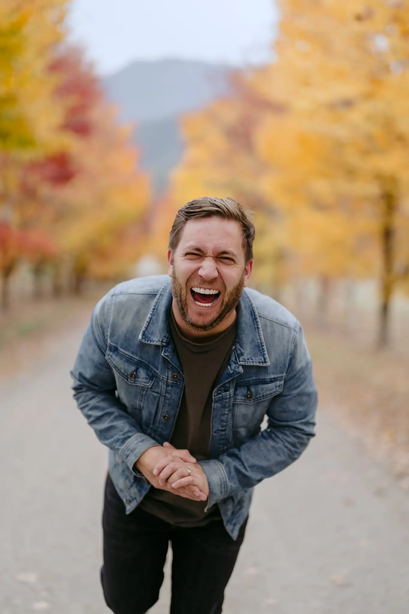 Michael Briggs laughing in an autumn avenue