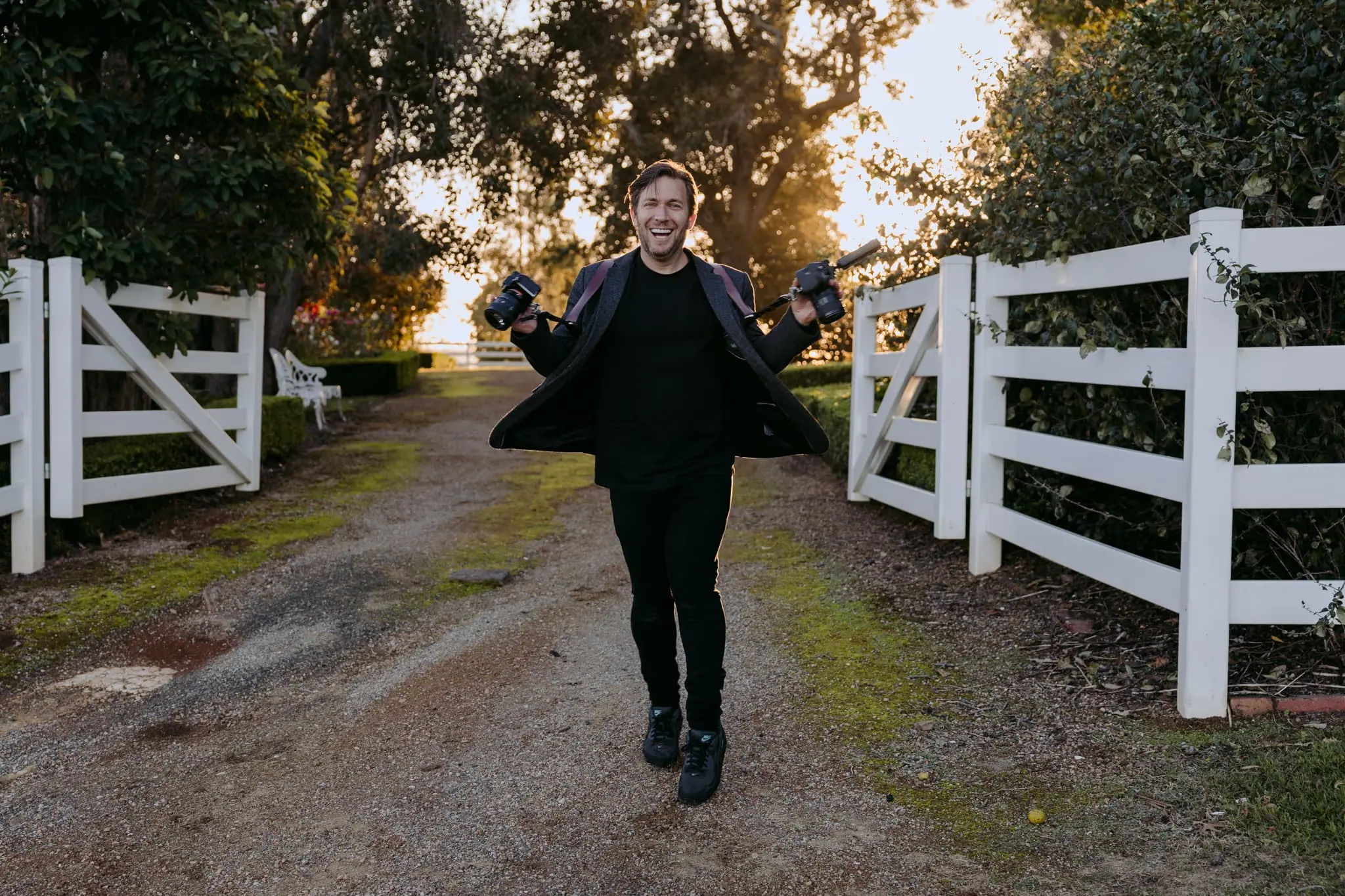 Michael Briggs walking a country driveway with two cameras