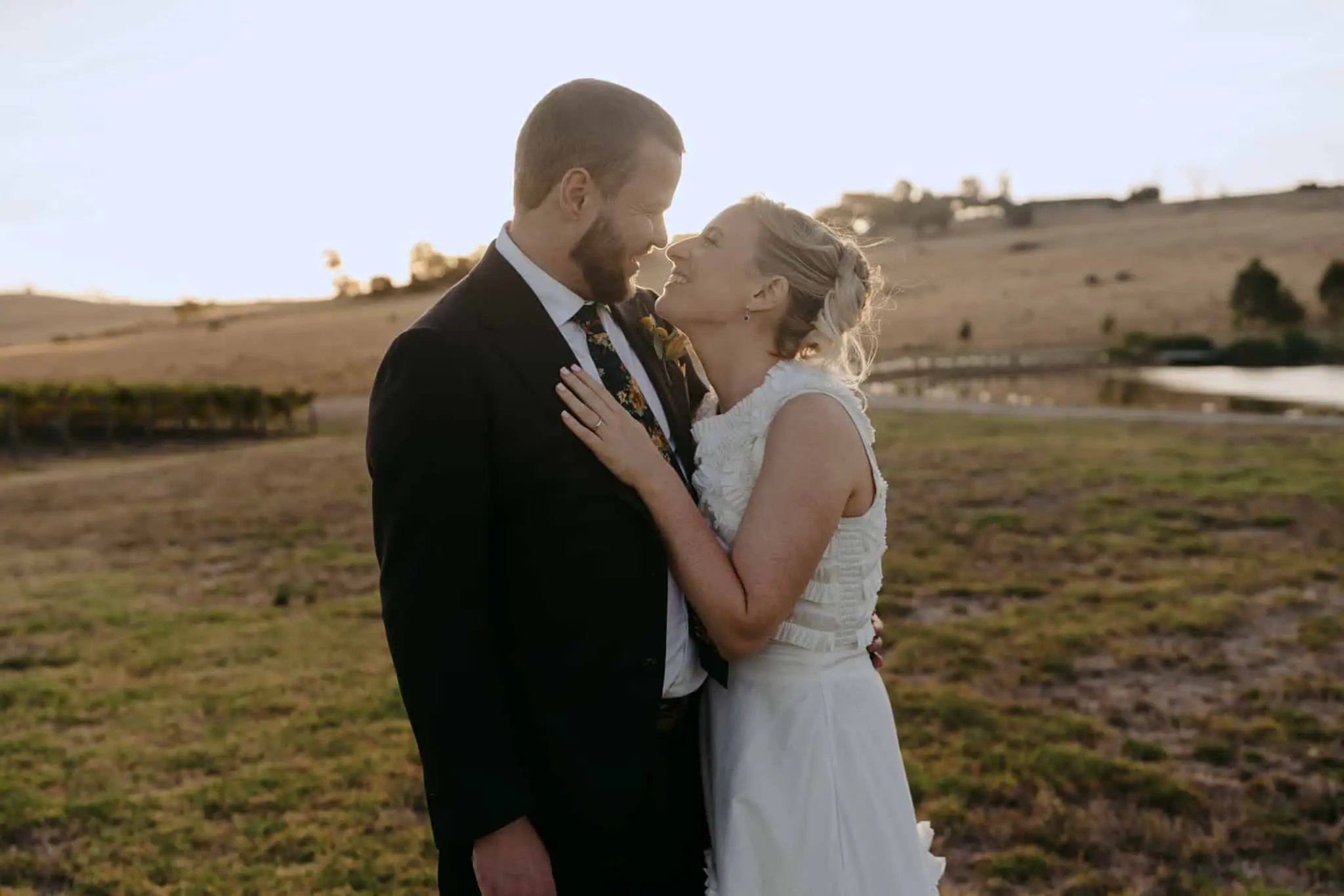 Couple touching foreheads in a field at dusk