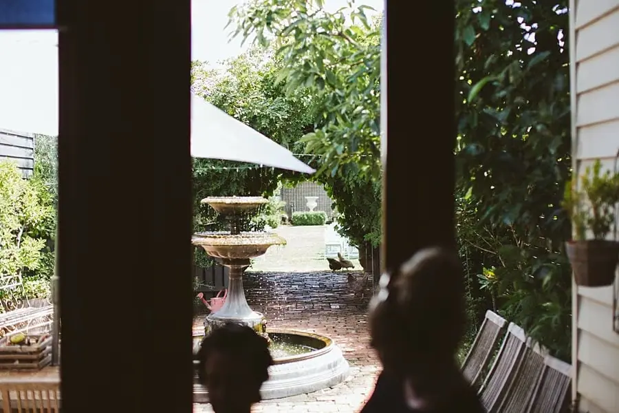 View from a shaded veranda toward a garden fountain.