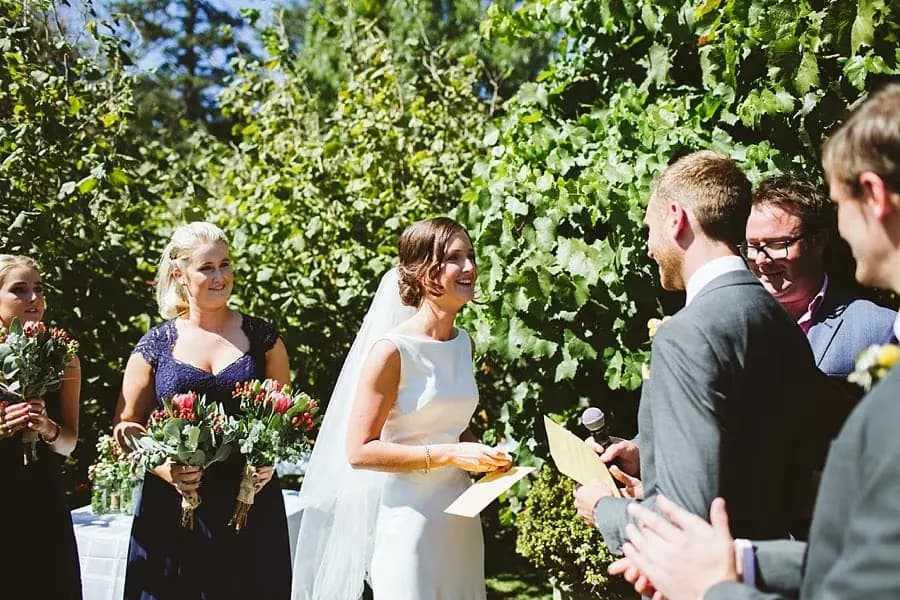 Bride reads from a yellow card beside the groom and celebrant.