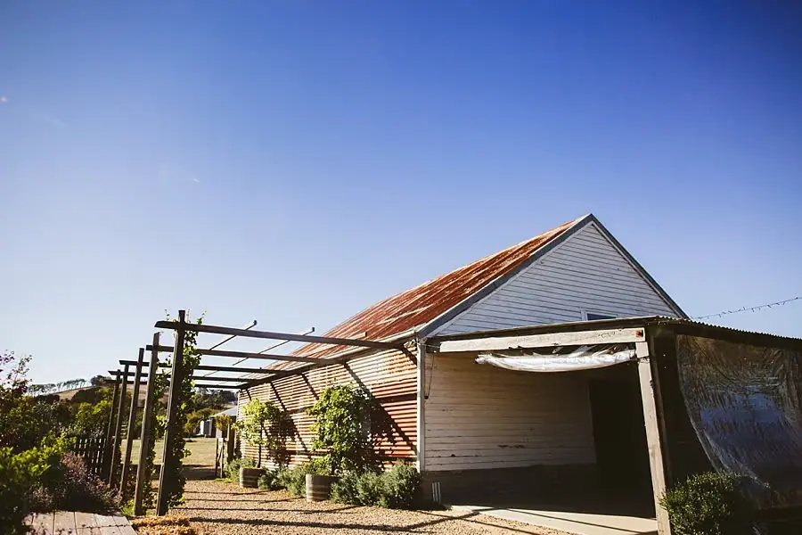 Rustic reception barn beneath a clear blue sky.