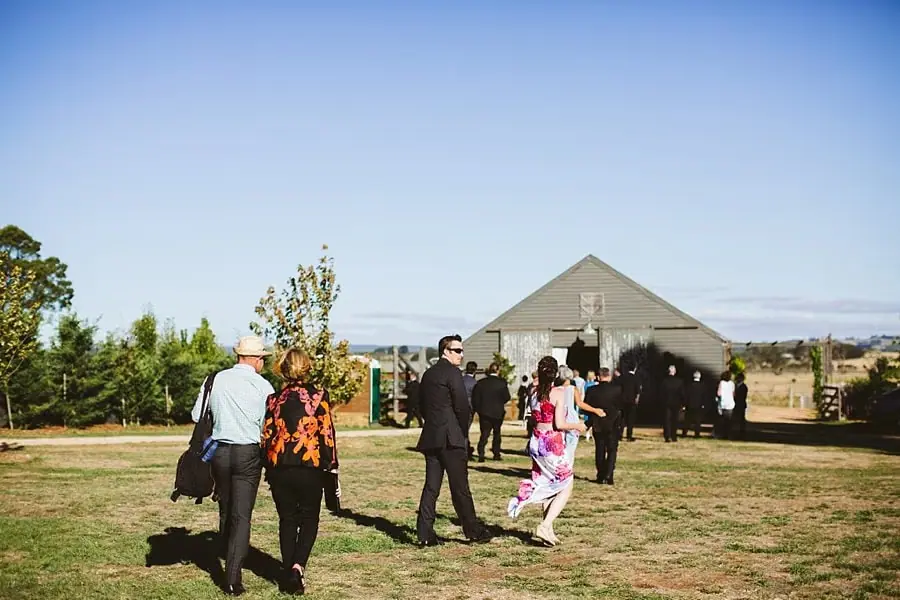 Guests walk across the lawn toward the reception barn.