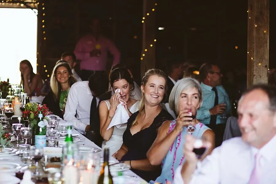 Women react with smiles and tissues at the reception table.