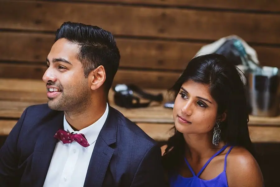 Two guests watch a reception speech while seated together.