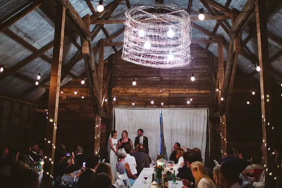Guests listen to a speech beneath timber rafters and a hanging light fitting.