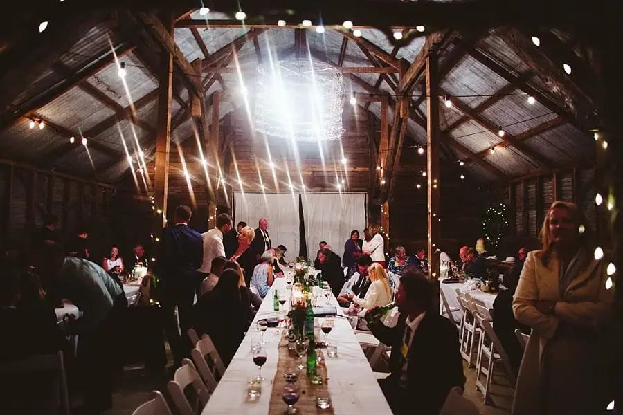 Guests gather around the reception tables beneath bright overhead lights.