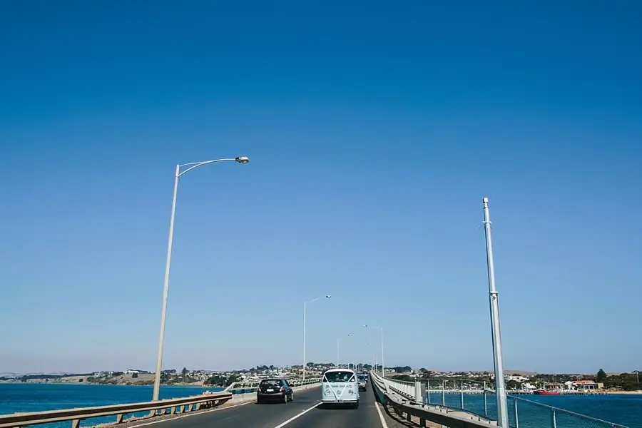 Vehicles traveling across a bridge beneath a clear blue sky.