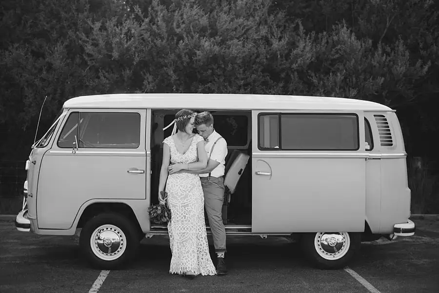 Black-and-white photograph of the couple embracing in the open doorway of a van.