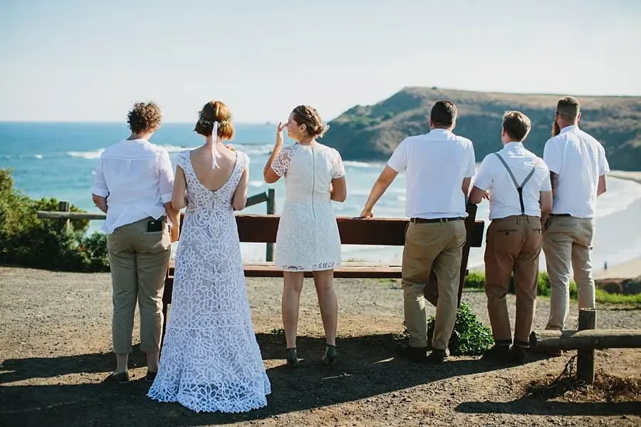 Wedding party looking out toward the ocean from a coastal lookout.