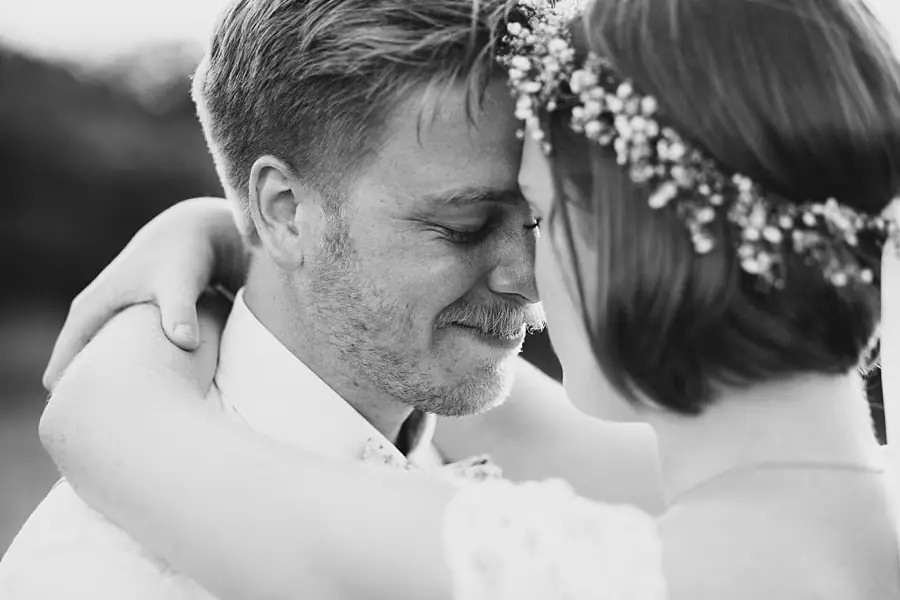 Black-and-white close-up of the couple resting their foreheads together.
