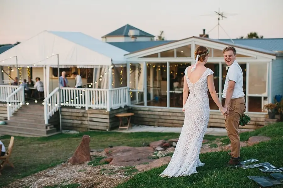 Bride and groom standing on the lawn outside the reception house.