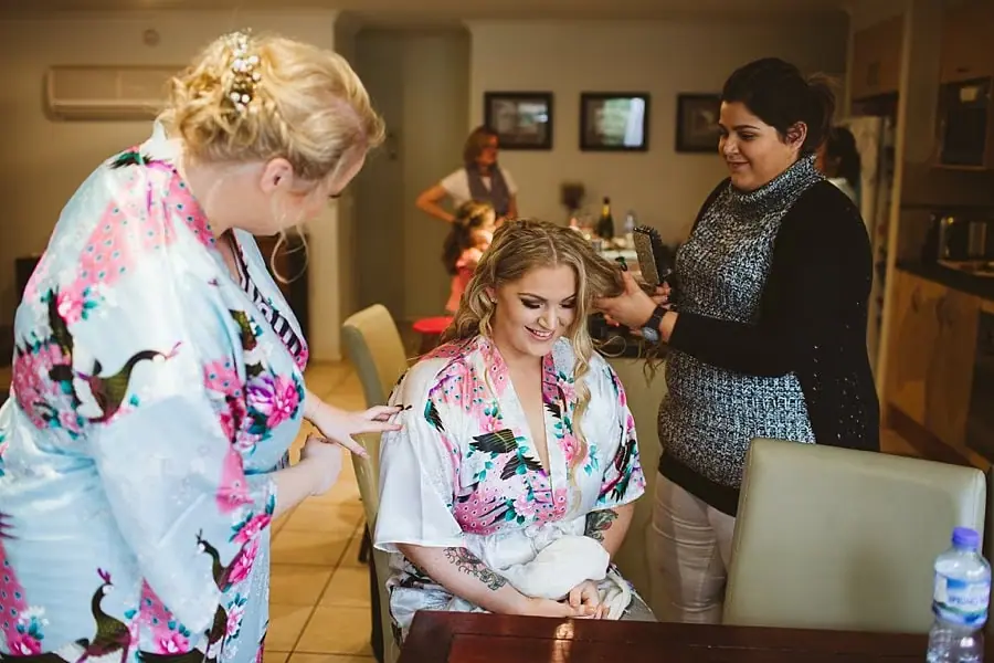 Women get ready with hair and makeup help indoors.