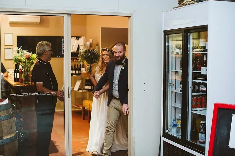 Bride and groom entering the reception through a doorway.