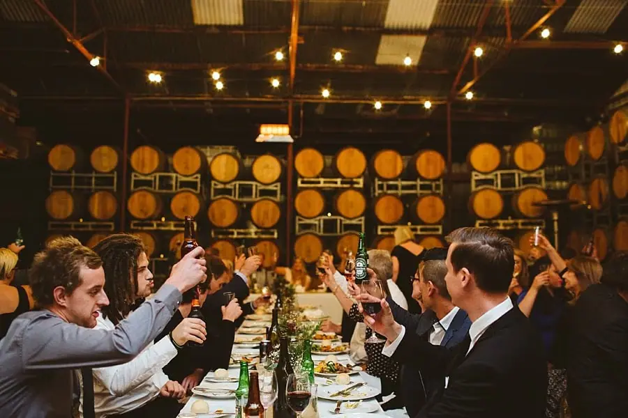 Guests raising their glasses around a long reception table.