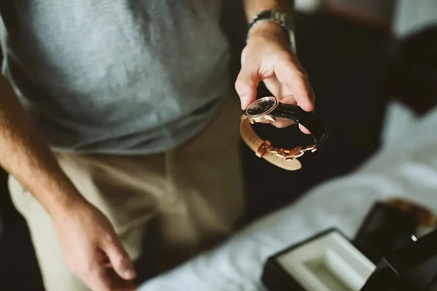 Close-up of a man holding a wristwatch and strap.
