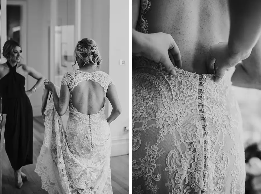 Two black-and-white photographs of the bride's open-backed lace dress being fastened.