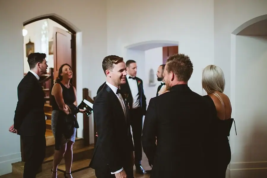 Men in suits chatting inside a church.
