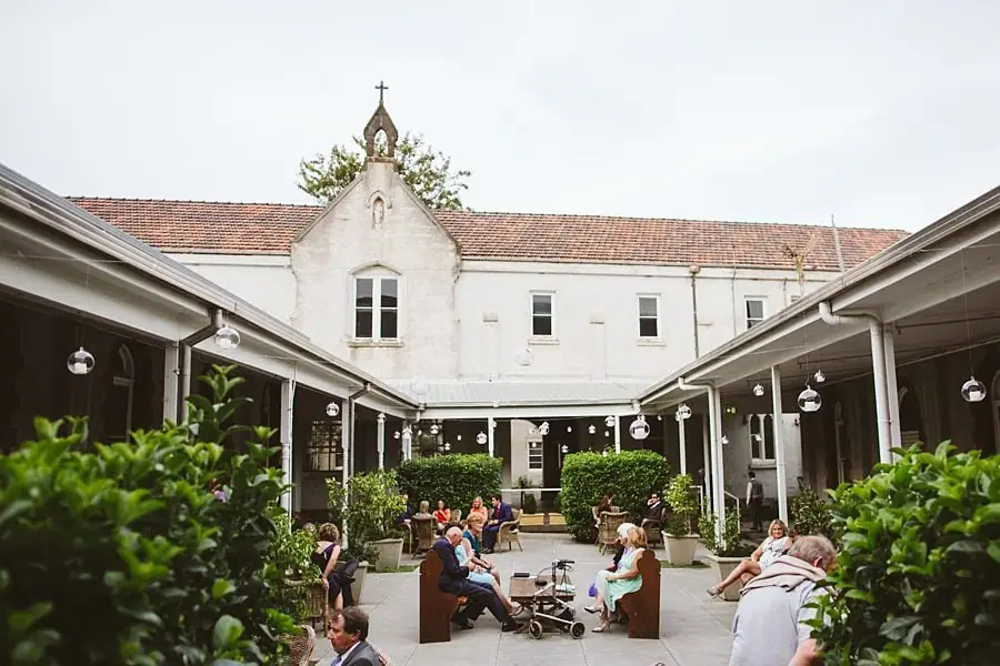 Guests seated in a planted courtyard surrounded by verandas.
