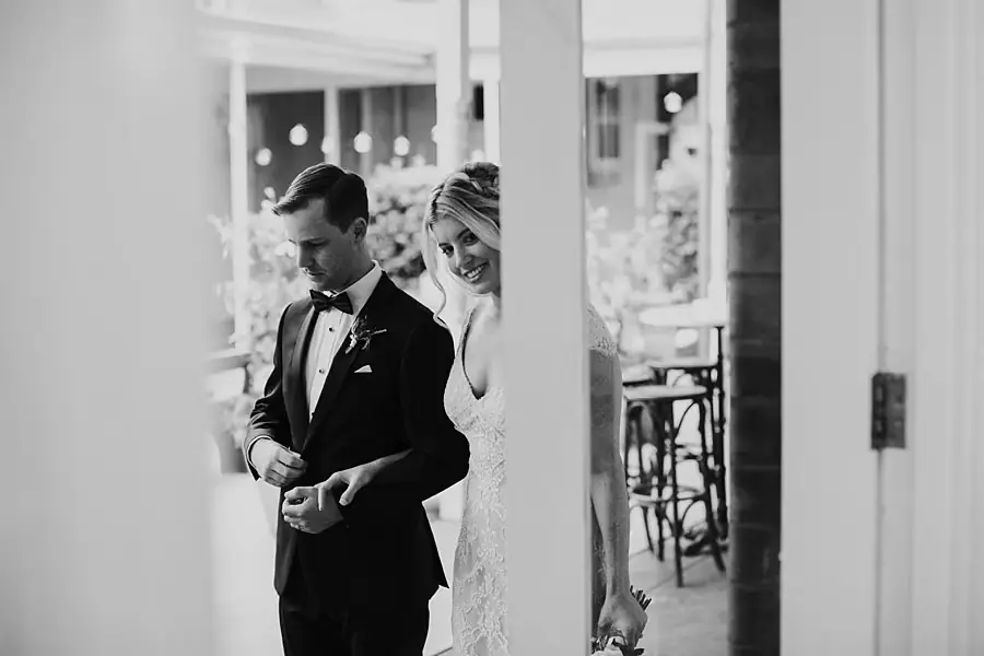 Black-and-white photograph of the couple smiling in a doorway.