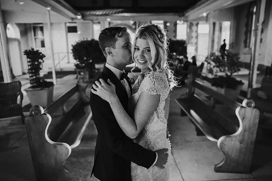 Black-and-white portrait of the bride and groom embracing at night.