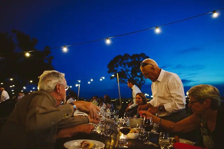 Guests enjoying dinner beneath the festoon lights