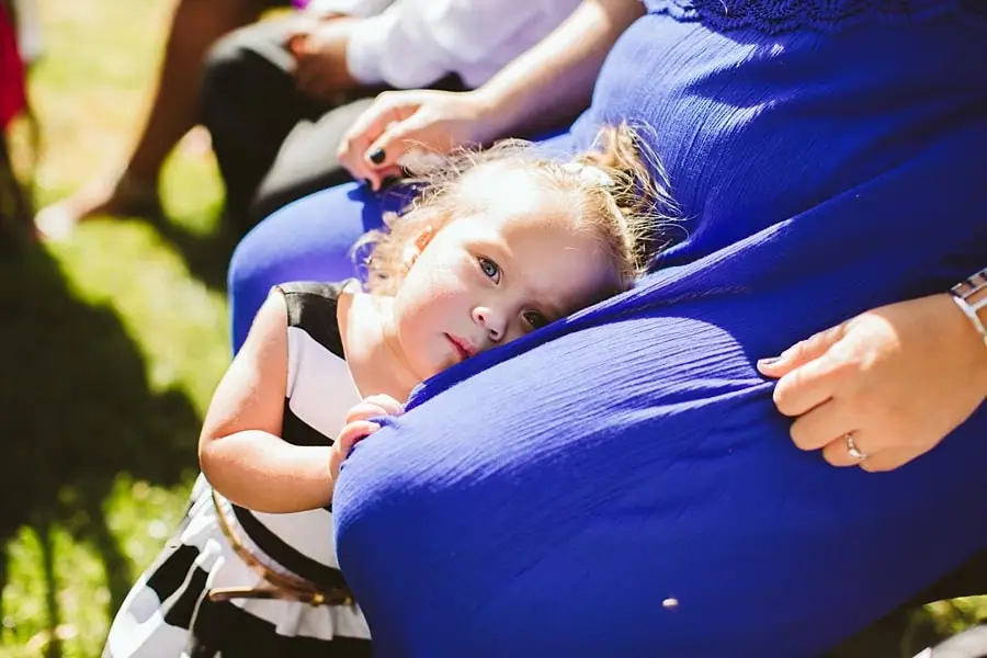 Child resting against a seated wedding guest