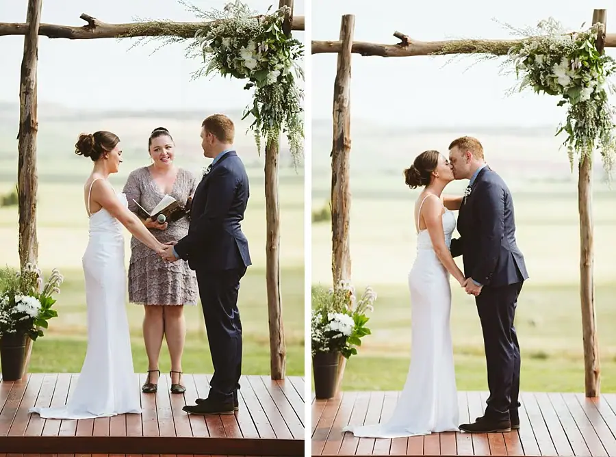 Couple exchanging rings and kissing beneath the ceremony arbour
