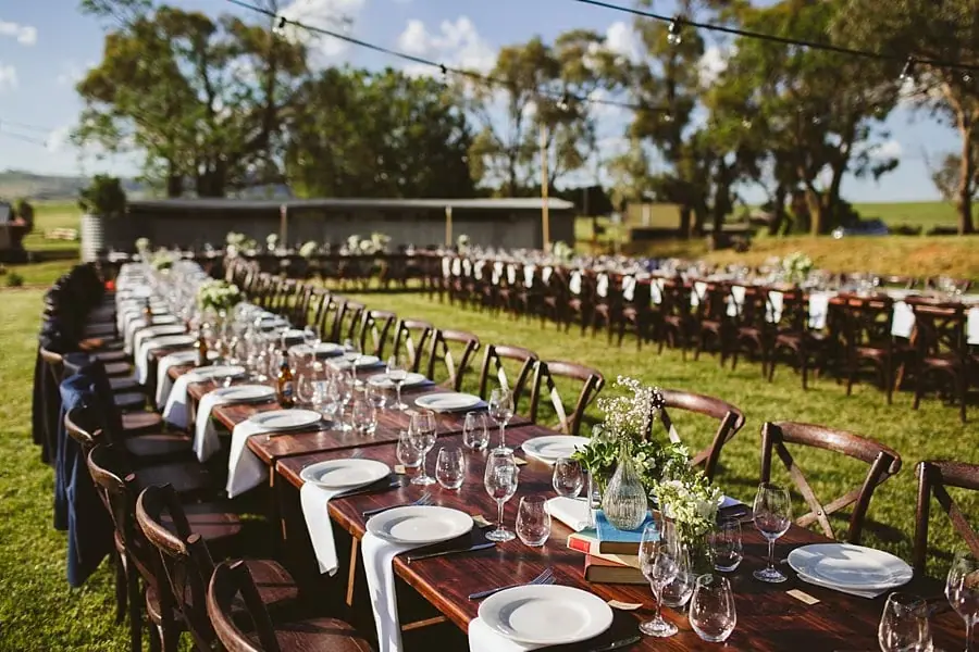 Long reception table set with plates, glassware and flowers