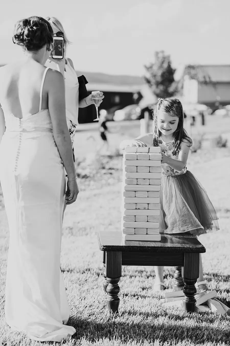 Bride playing a lawn game with a young guest