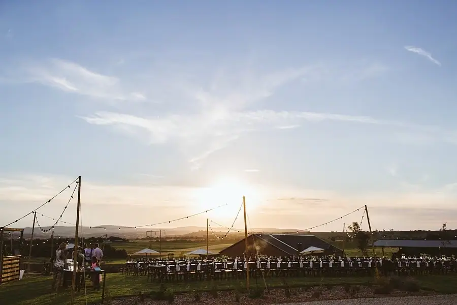 Reception tables and festoon lights at sunset
