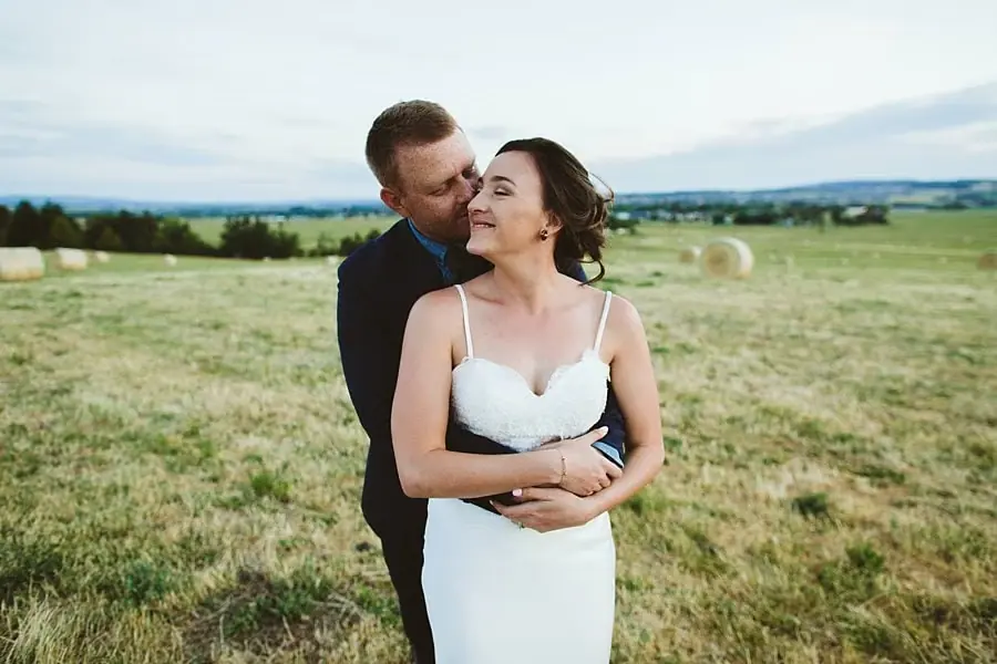 Groom embracing the bride from behind