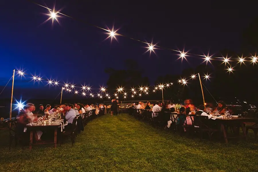 Wide view of the outdoor reception tables at night