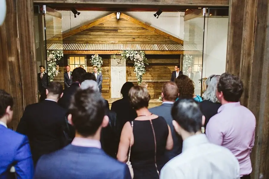 Guests standing and looking toward the ceremony backdrop.