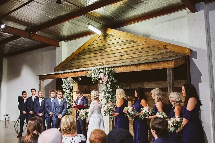 Wide view of the wedding party during an indoor ceremony.