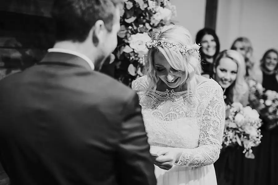 Black-and-white photograph of the bride laughing while facing the groom.