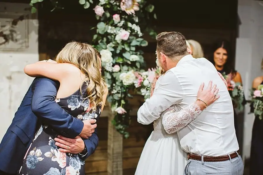 Bride and groom embracing guests after their ceremony.
