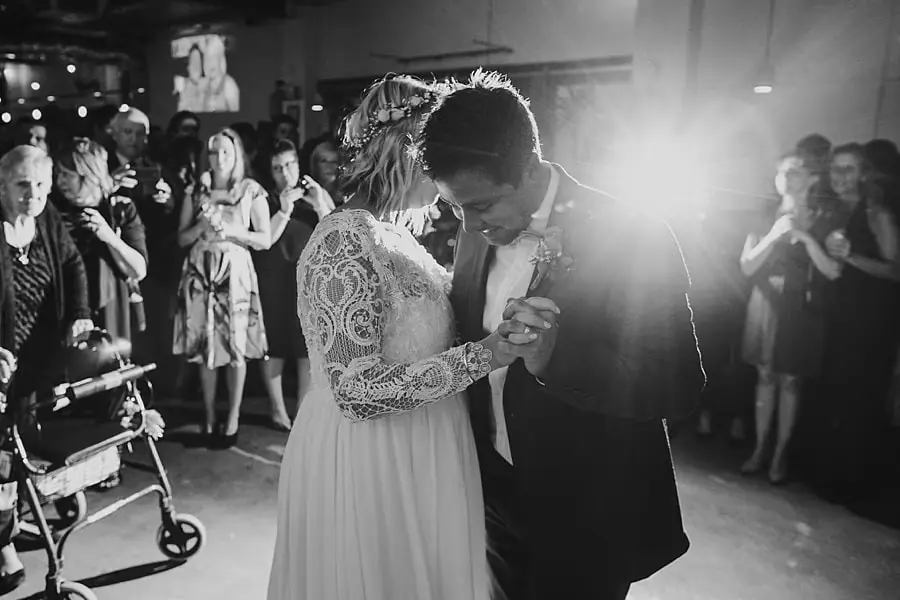 Black-and-white photograph of the couple dancing with a bright light behind them.