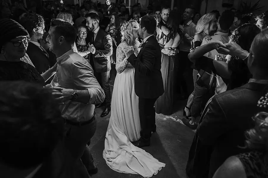 Black-and-white photograph of the couple and guests dancing together.