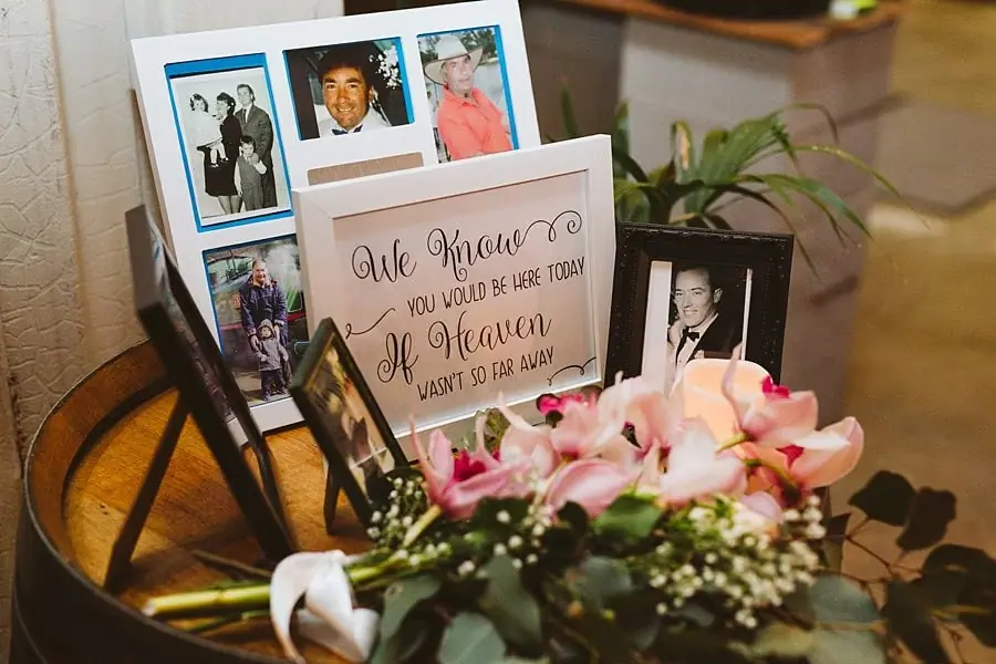 Framed photographs and a remembrance message arranged with flowers.