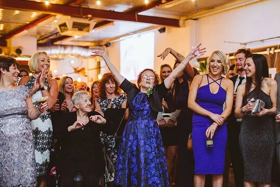 Guests laughing and raising their hands in the reception room.