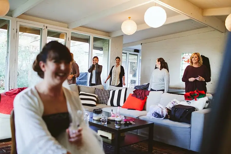 Women smiling and chatting in a living room before the wedding.