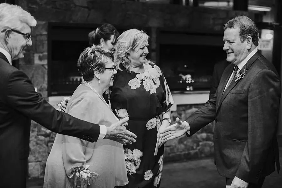 Black-and-white photograph of older guests greeting each other at the reception.