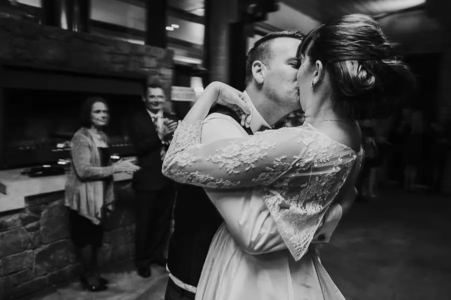 Black-and-white photograph of the couple kissing on the dance floor.