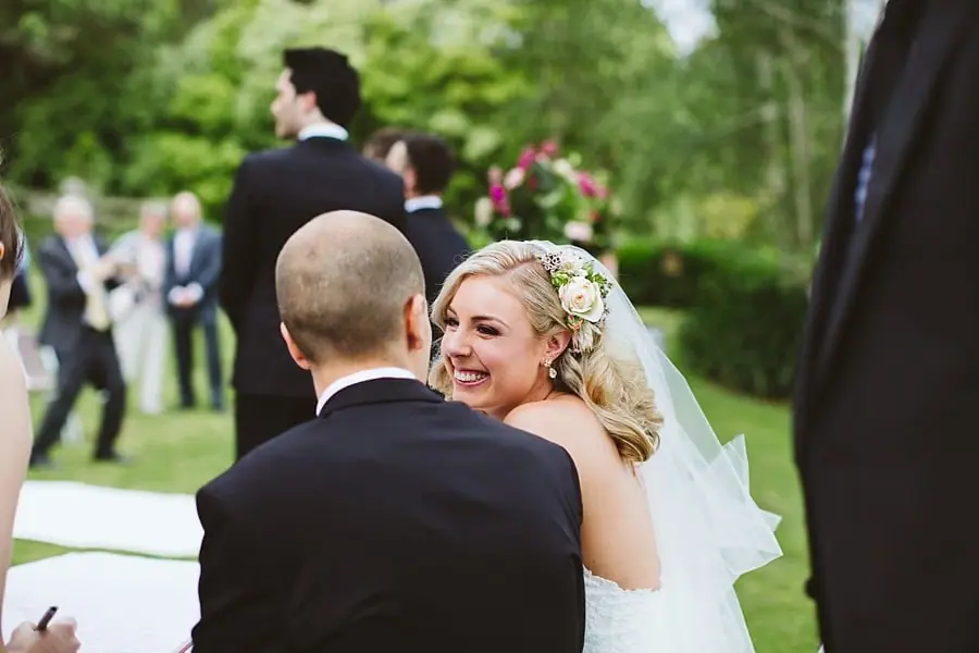 Bride looking back and smiling while embracing the groom after their ceremony.