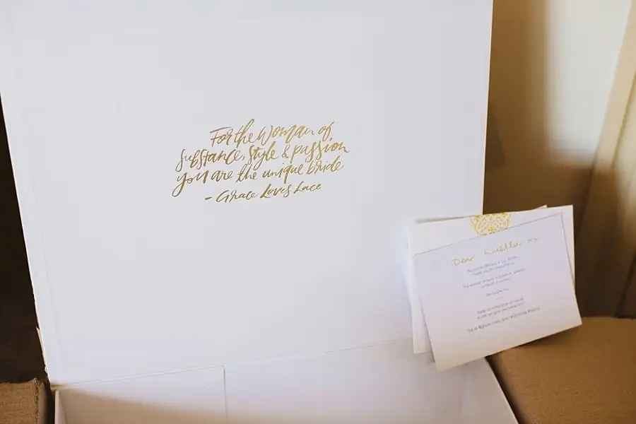 White gift box and envelope with gold-colored lettering.