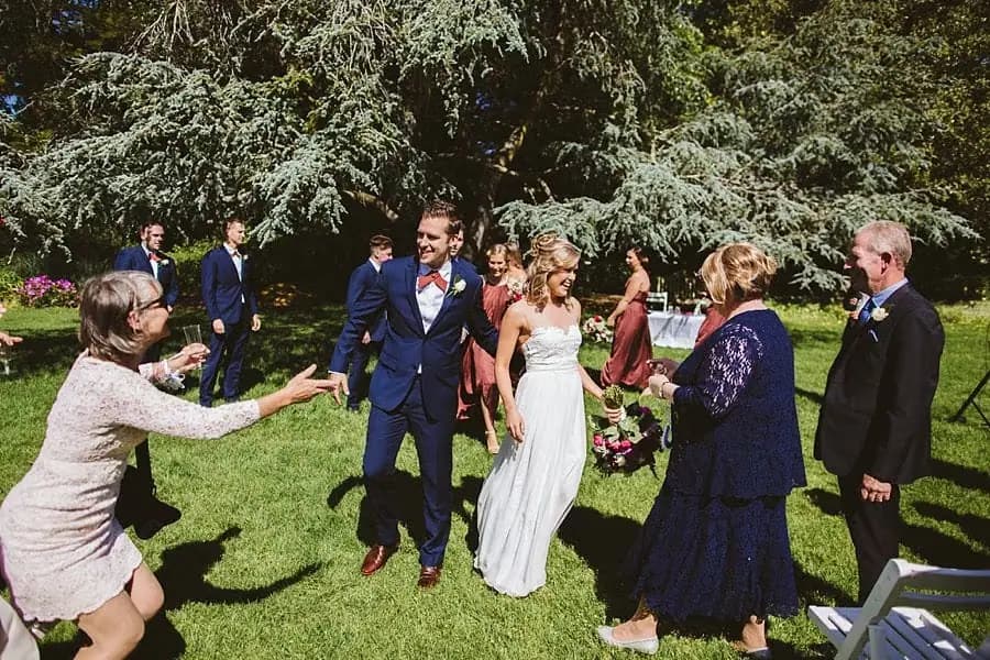 Guests approaching the couple for hugs on the ceremony lawn.